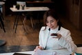 Young asian businesswoman beautiful charming smiling and talking on the mobile phone with speaker phone in the office Royalty Free Stock Photo