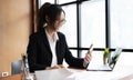 Young asian businesswoman beautiful charming smiling and using on mobile phone in the office. Royalty Free Stock Photo