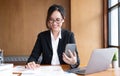 Young asian businesswoman beautiful charming smiling and using on mobile phone in the office. Royalty Free Stock Photo