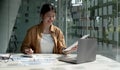 Young Asian businesswoman is happy to work at the modern office using laptop and calculator, working on project, checking Royalty Free Stock Photo