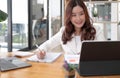 Young Asian businesswoman is happy to work at the modern office using a tablet. Royalty Free Stock Photo