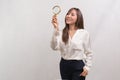 Young asian businesswoman holding magnifying glass over white background, analysis and finance concept Royalty Free Stock Photo