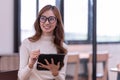 Young Asian businesswoman holding a tablet working In the office room Royalty Free Stock Photo