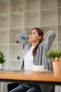 Young asian businesswoman or office worker stretching her arms, hand behind her head Royalty Free Stock Photo