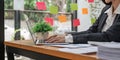 Young asian businesswoman sitting at bright work and typing on laptop in office Royalty Free Stock Photo