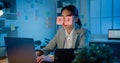 Young Asian businesswoman sitting on desk overworked tired sleep over a laptop at office at night. Exhausted burnout lady with two Royalty Free Stock Photo