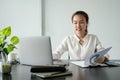 Young asian businesswoman sitting on her workplace in the office. Young woman working at laptop in the office Royalty Free Stock Photo