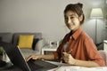 Young Asian businesswoman sitting at home working on laptop computer. Asian woman studying online using laptop surfing information Royalty Free Stock Photo