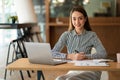 A young Asian businesswoman stands in front of her desk holding a smirked tablet. money business idea Royalty Free Stock Photo