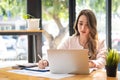 A young Asian businesswoman stands in front of her desk holding a smirked tablet. money business idea Royalty Free Stock Photo