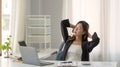 Young Asian businesswoman stretching arms raised relaxing at the office. Royalty Free Stock Photo