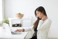 Young asian businesswoman feels neck pain after sedentary comput