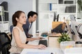 Young asian businesswoman using laptop at office table. company employees sitting at work, Accounting staff working towards