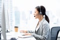 Asian businesswoman wearing headsets working in call center city office