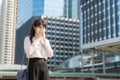 Young Asian businesswoman in white shirt going to work feeling sick with cough wears protection mask prevent PM2.5 dust, smog, air Royalty Free Stock Photo