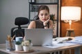 Young Asian businesswoman working on laptop computer, stressed has a headache and thinks hard from work at the office. Royalty Free Stock Photo