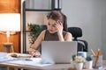 Young Asian businesswoman working on laptop computer, stressed has a headache and thinks hard from work at the office. Royalty Free Stock Photo