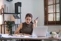 Young Asian businesswoman working on laptop computer, stressed has a headache and thinks hard from work at the office. Royalty Free Stock Photo