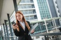 A young Asian businesswomen wearing a suit holding files standing in a big city on a busy downtown street. Young Asian Royalty Free Stock Photo