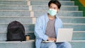 Young asian campus student man wearing protection mask while sitting in campus, coronavirus prevention in university, social Royalty Free Stock Photo