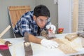 Young asian carpenter holding sanding machine polishing on wooden job Royalty Free Stock Photo