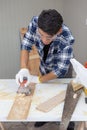 Young asian carpenter holding sanding machine polishing on wooden job Royalty Free Stock Photo