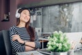 Young asian casual businesswoman arm on desk rest pose with laptop computer and listening music via headphone and looking through Royalty Free Stock Photo