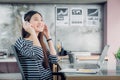 Young asian casual businesswoman arm on desk rest pose with laptop computer and listening music via headphone at home office ,wor Royalty Free Stock Photo