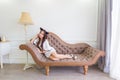 Young asian cat woman is lying on a couch in modern room Royalty Free Stock Photo