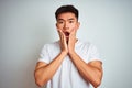 Young asian chinese man wearing t-shirt standing over isolated white background afraid and shocked, surprise and amazed expression Royalty Free Stock Photo