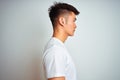 Young asian chinese man wearing t-shirt standing over isolated white background looking to side, relax profile pose with natural Royalty Free Stock Photo
