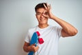 Young asian chinese student man holding skate standing over isolated white background with happy face smiling doing ok sign with Royalty Free Stock Photo