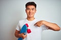 Young asian chinese student man holding skate standing over isolated white background with surprise face pointing finger to Royalty Free Stock Photo