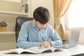 Young Asian college male student writing notes, using laptop for learning online education, business learning, watching online Royalty Free Stock Photo