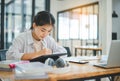 Young Asian college student doing report, drawing on tablet in cafe. Communicating and researching online Royalty Free Stock Photo