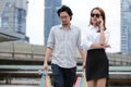 Young Asian couple carrying colorful shopping bags on city street Royalty Free Stock Photo