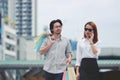 Young Asian couple carrying colorful shopping bags on city street Royalty Free Stock Photo