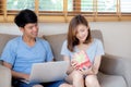 Young asian couple celebrate birthday together, asia man giving gift box present to woman for surprise at living room Royalty Free Stock Photo