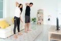 Young Asian couple doing High-intensity interval training together and looking TV at home, man and woman working out together