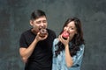 Young asian couple enjoy eating of sweet colorful donut Royalty Free Stock Photo