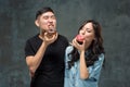 Young asian couple enjoy eating of sweet colorful donut Royalty Free Stock Photo