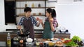 Young Asian couple are happy to cook together, two families are helping each other prepare to cook in the kitchen Royalty Free Stock Photo