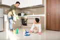 Young Asian couple having fun while doing spring cleaning together