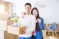 Young asian couple holding keys of new house, smiling happy and excited moving to a new apartment Royalty Free Stock Photo