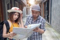 Young Asian couple holding map looking direction on honeymoon vacation.