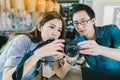 Young Asian couple learning to use mirrorless digital camera together at coffee shop Royalty Free Stock Photo