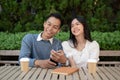 Young Asian couple listening to music together, having fun together in the green park Royalty Free Stock Photo