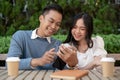 Young Asian couple listening to music together, having fun together in the green park Royalty Free Stock Photo