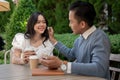 Young Asian couple listening to music together, having fun together in the green park Royalty Free Stock Photo