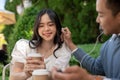 Young Asian couple listening to music together, having fun together in the green park Royalty Free Stock Photo